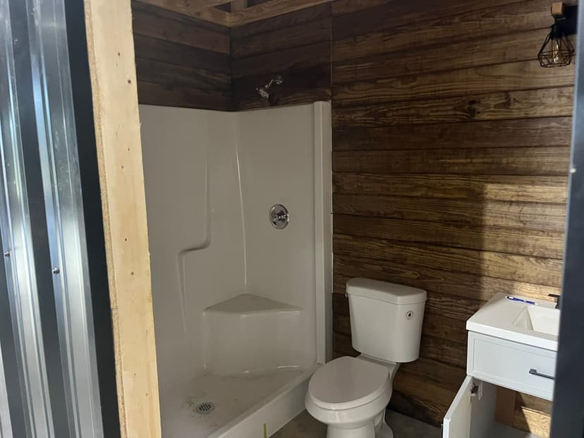 Modern bathroom interior featuring a walk-in shower, toilet, and minimalist vanity design.